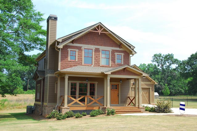 exterior of a brown residential home on a large blog of land